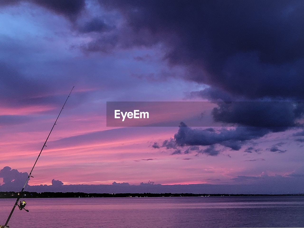 FISHING ROD OVER SEA AT SUNSET