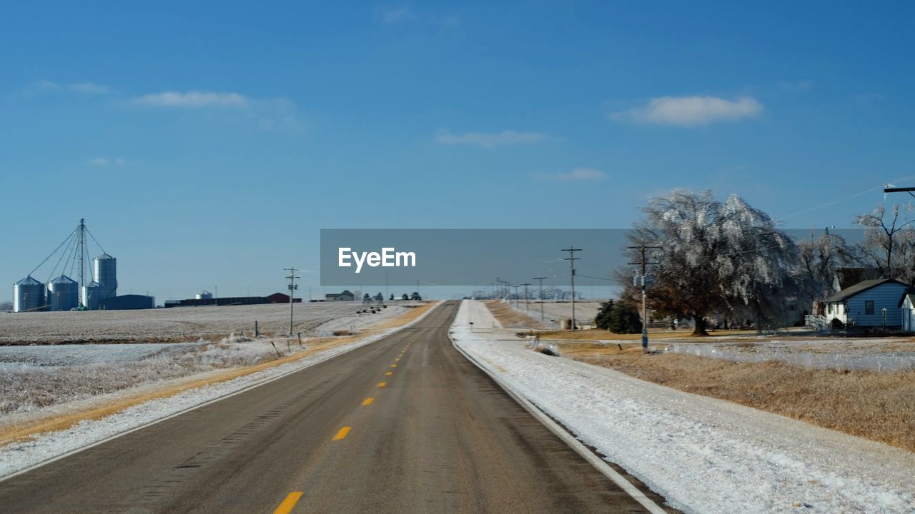 ROAD IN WINTER AGAINST SKY