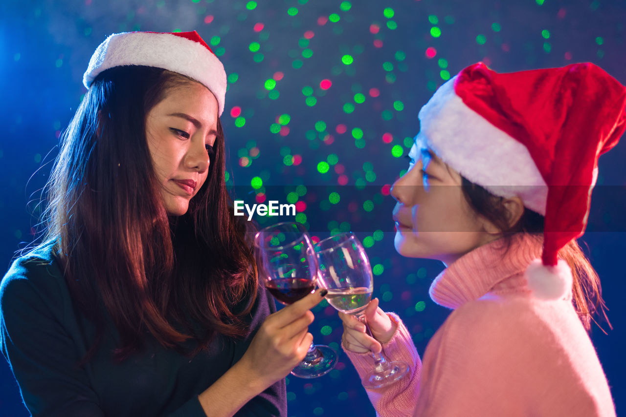 Close-up of female friends toasting during christmas