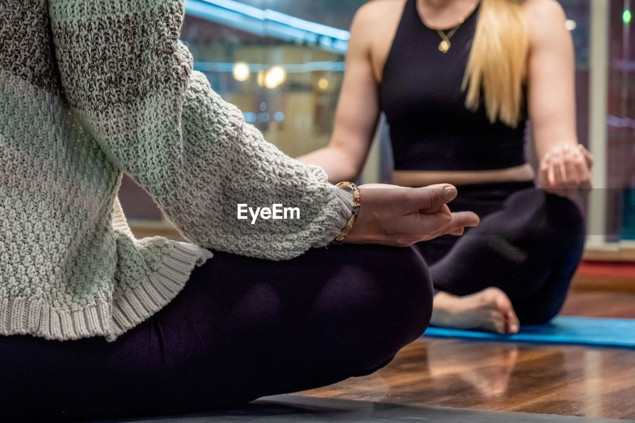 midsection of woman doing yoga at home