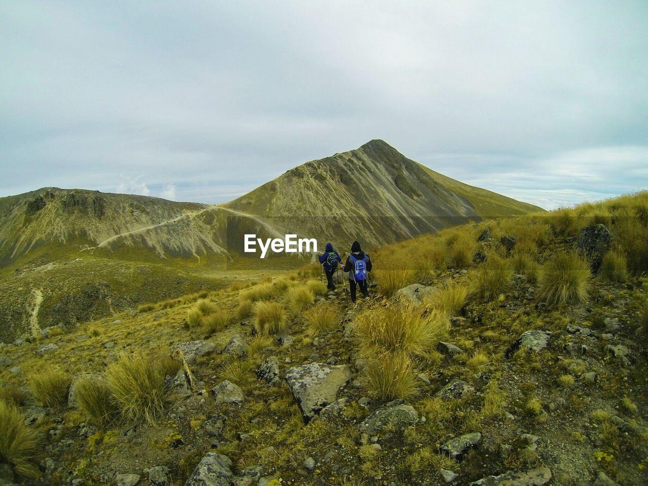 MAN HIKING ON MOUNTAIN PEAK