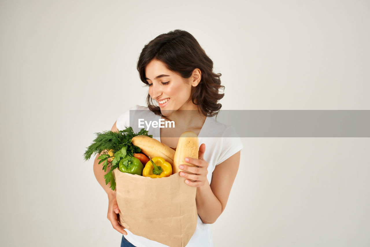 Young woman holding ice cream against white background