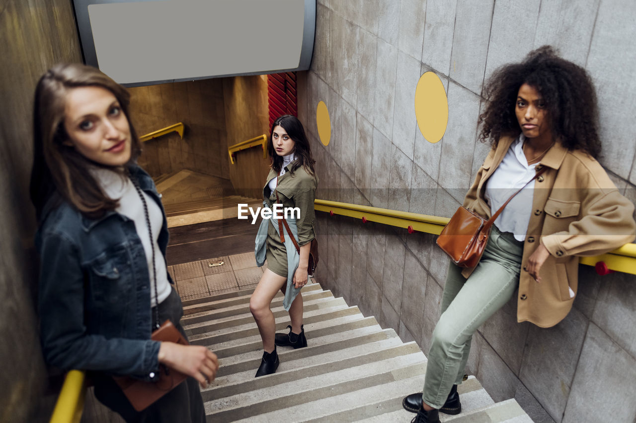 Young women staring while standing on staircase