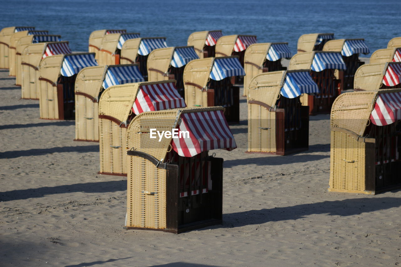 HOODED BEACH CHAIRS ON SAND AT SHORE