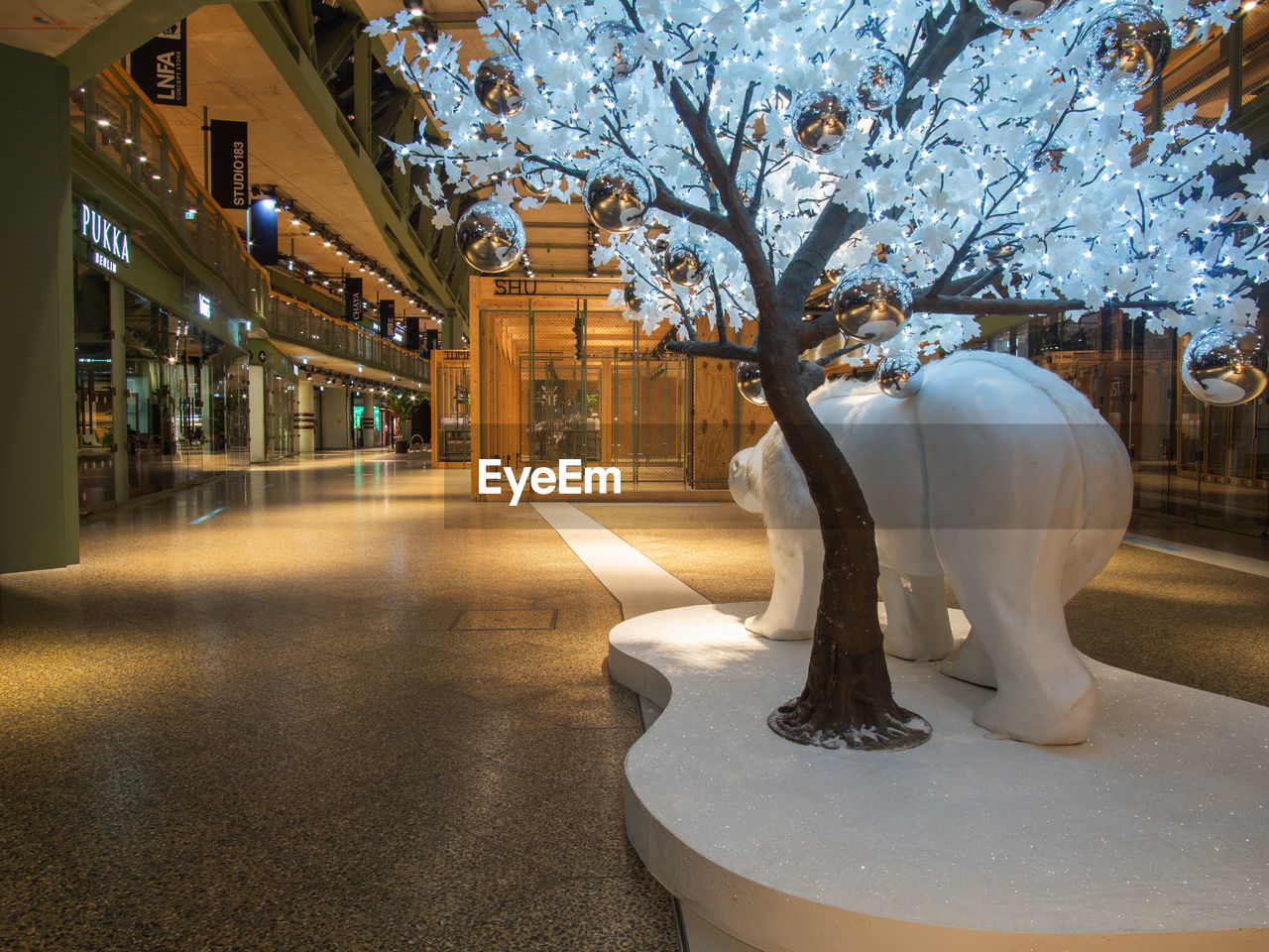 VIEW OF WHITE STATUE AGAINST ILLUMINATED TREES