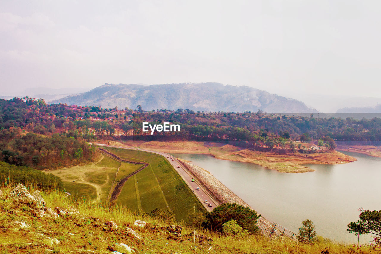 Scenic view of river by landscape against sky