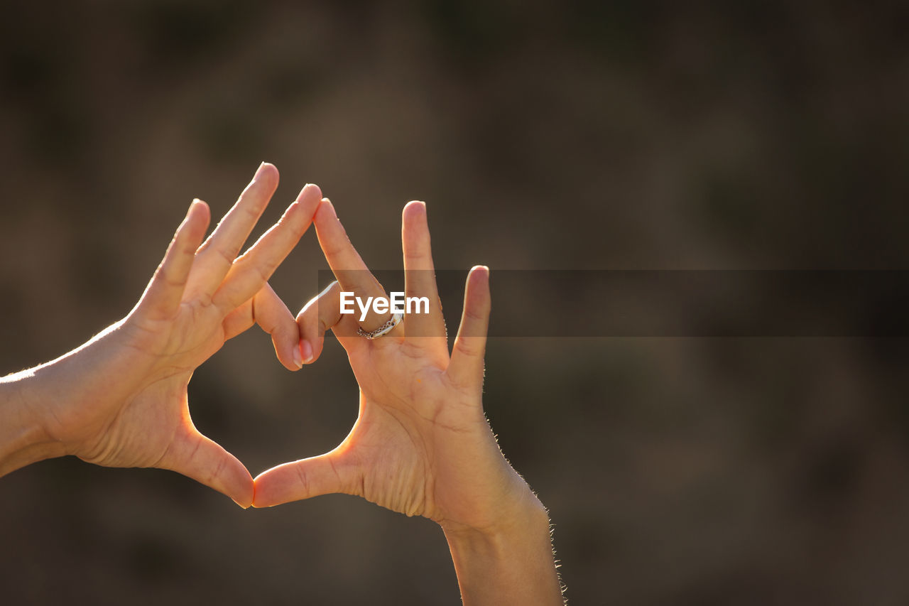 Close-up of hands gesturing heart shape