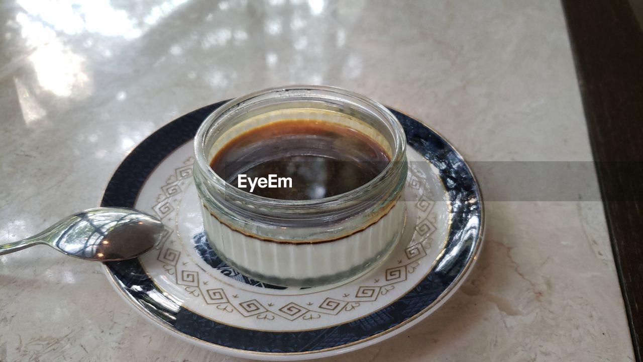 HIGH ANGLE VIEW OF TEA IN GLASS ON TABLE