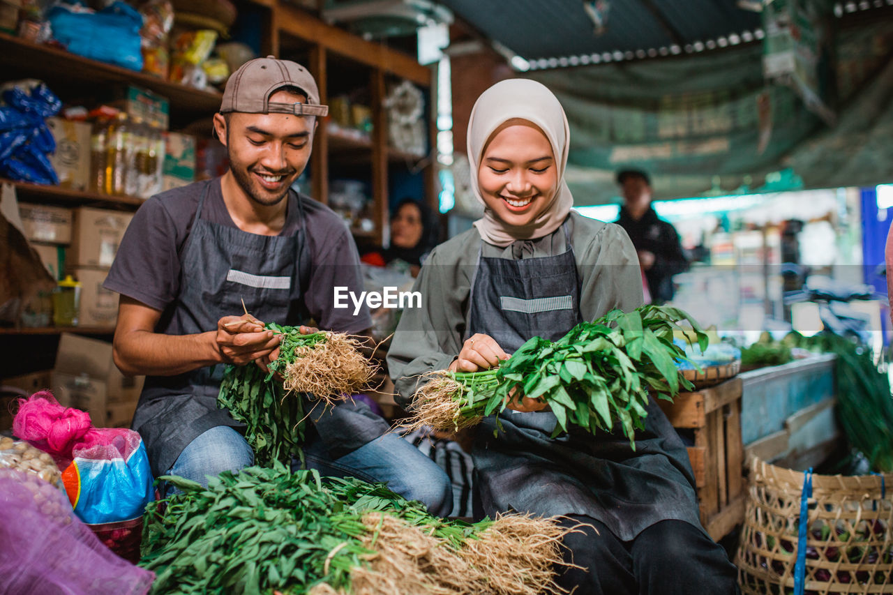 portrait of smiling man standing by vegetables for sale