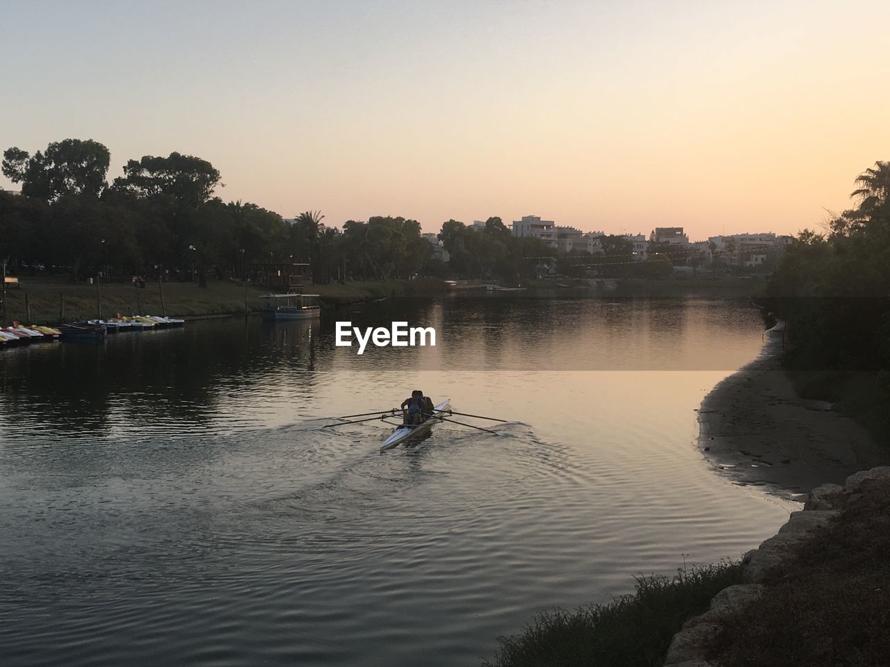 Silhouette man standing on river against clear sky