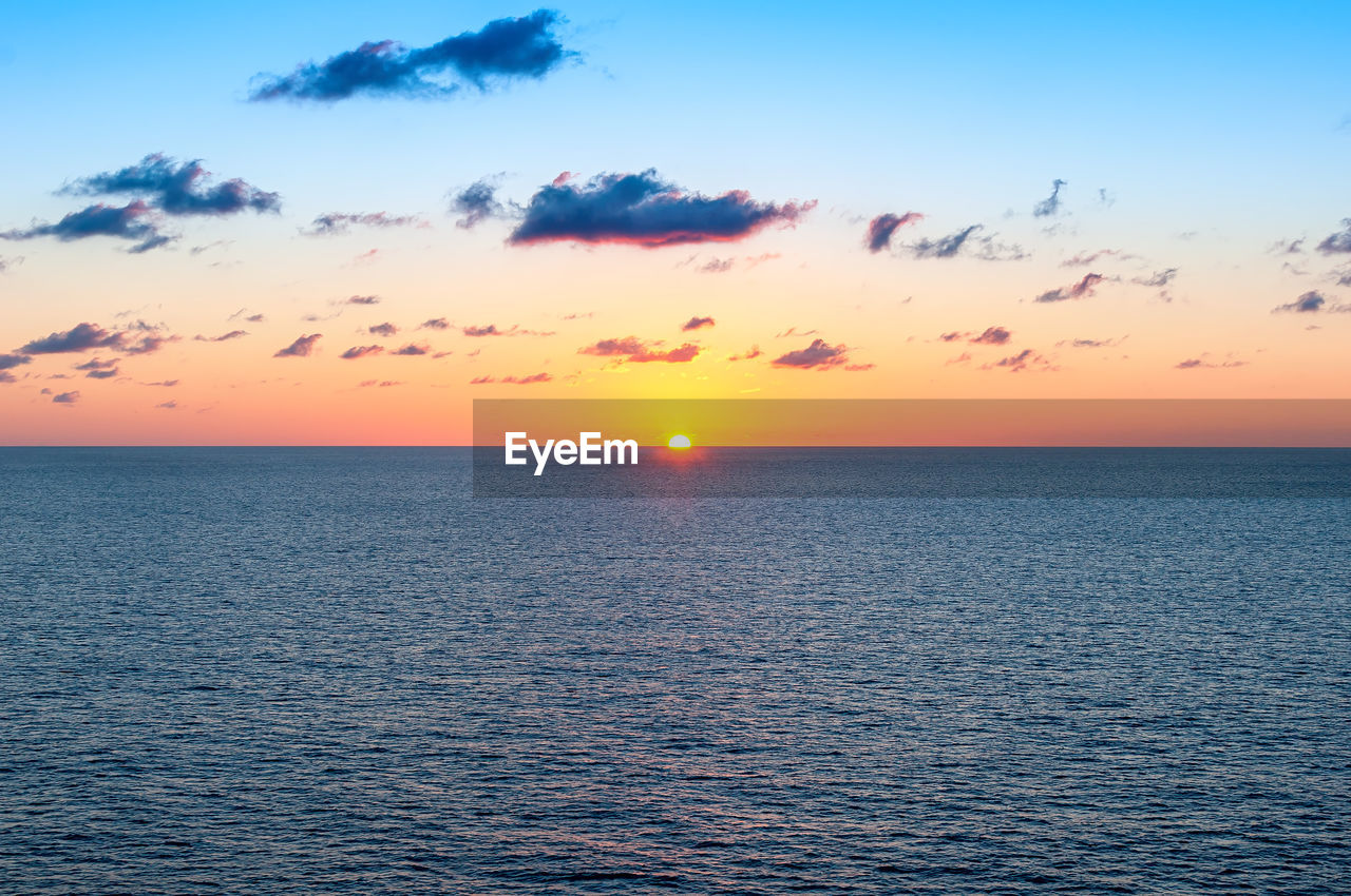 SCENIC VIEW OF SEA AGAINST ORANGE SKY