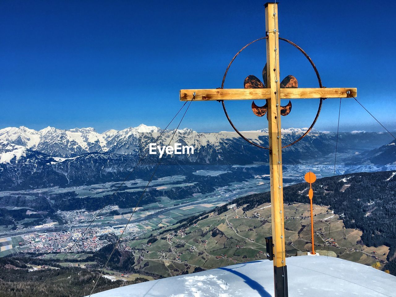 WINDMILL ON SNOWCAPPED MOUNTAINS AGAINST CLEAR BLUE SKY