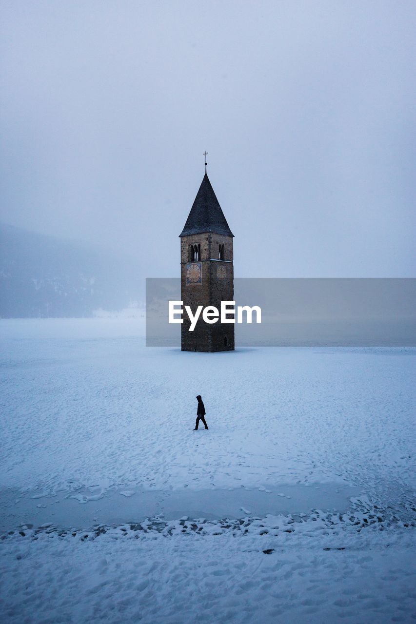 Man standing in front of building on snow covered field