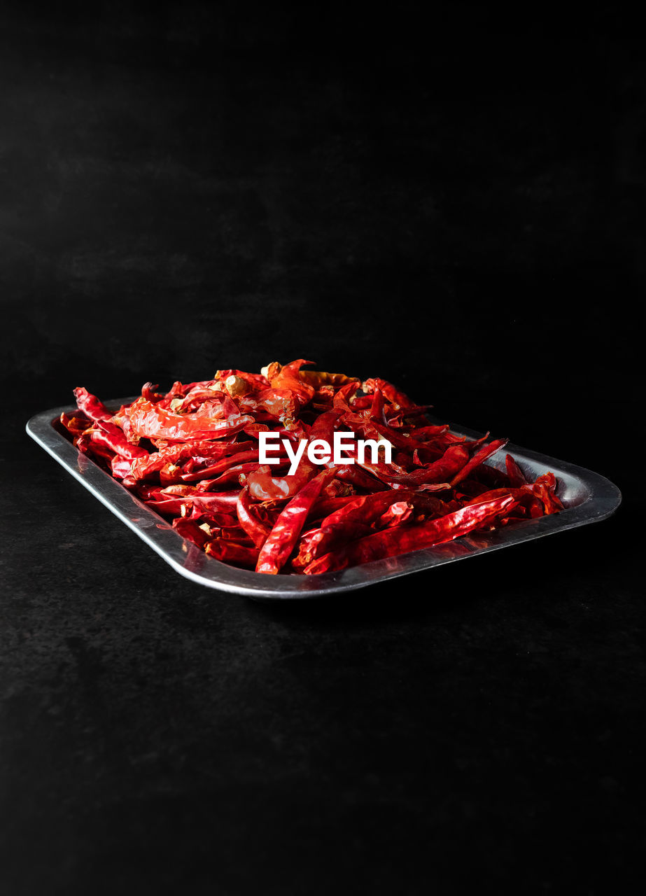 HIGH ANGLE VIEW OF RED CHILI PEPPERS ON PLATE