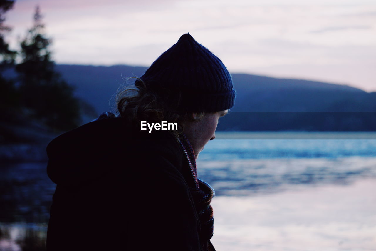 Man looking at lake during sunset