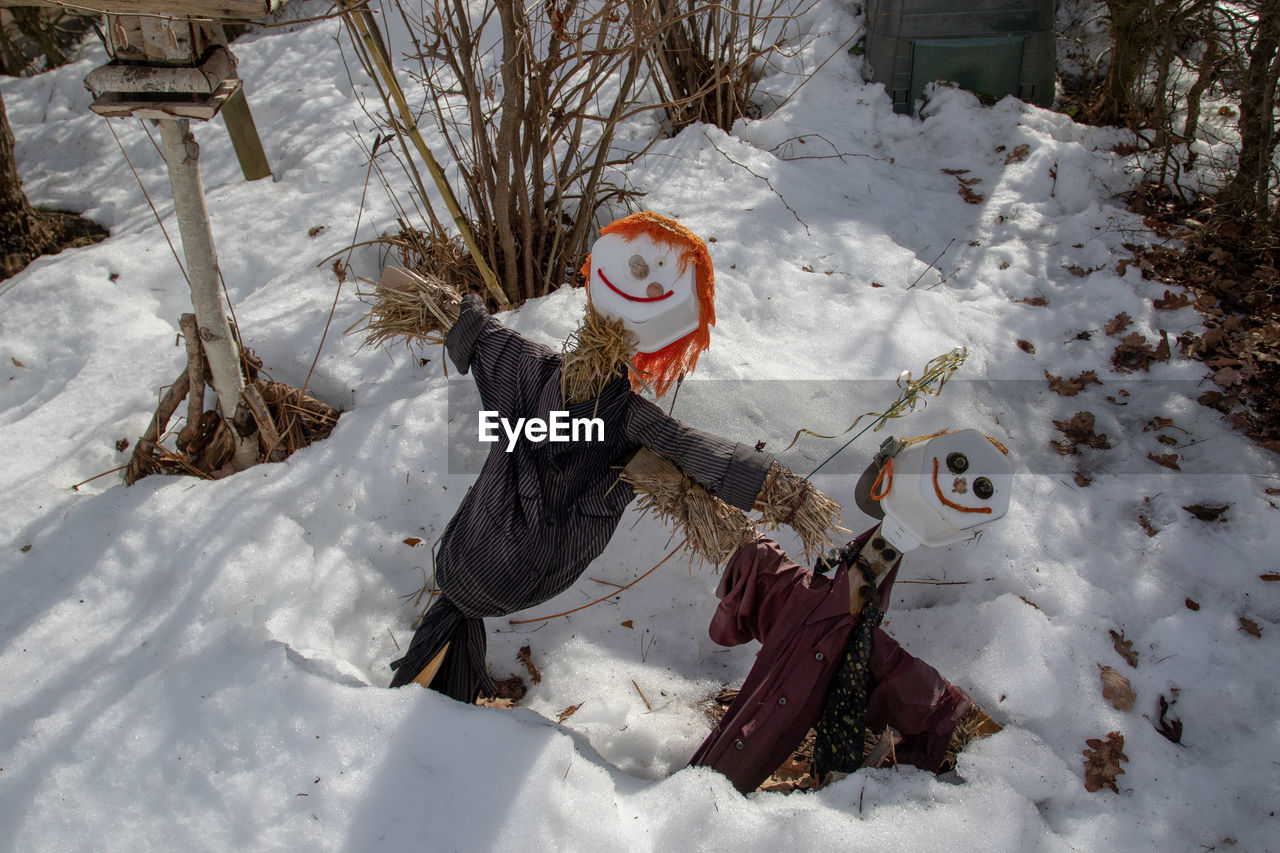 HIGH ANGLE VIEW OF CHILD ON SNOW COVERED FIELD