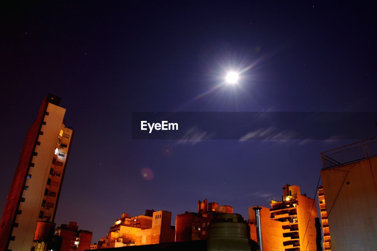 LOW ANGLE VIEW OF BUILDINGS AGAINST SKY AT NIGHT