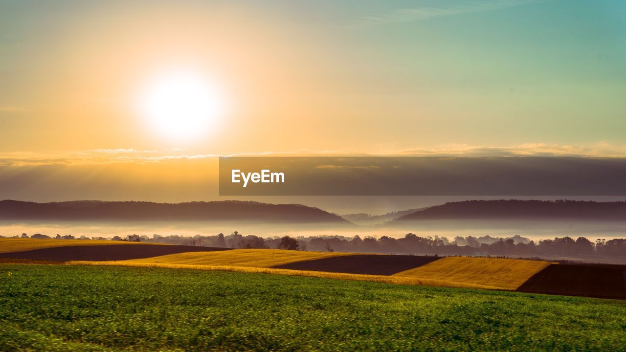 Scenic view of field against sky during sunset