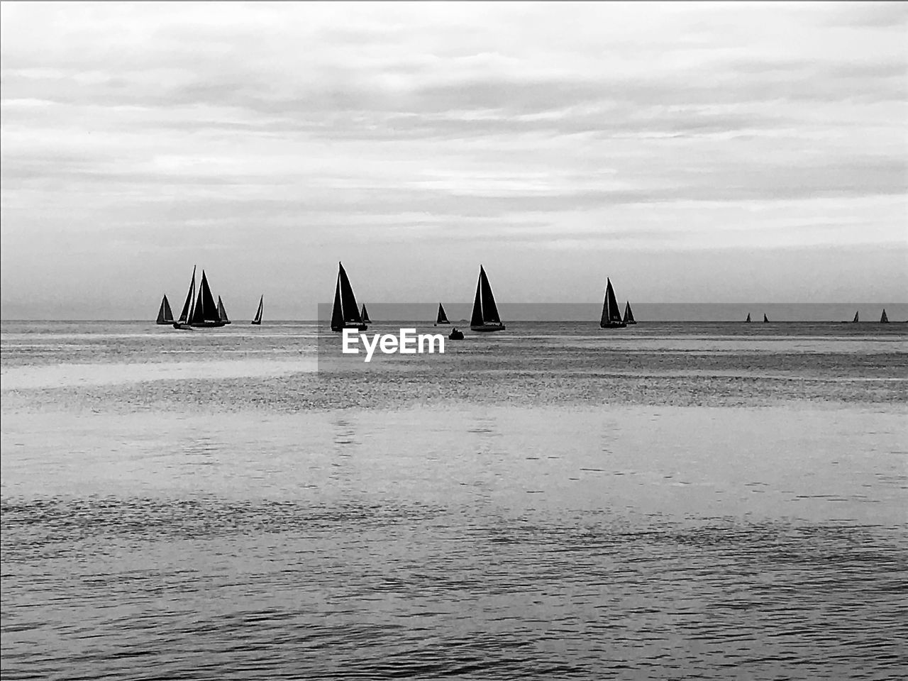 PEOPLE ON SAILBOAT SAILING IN SEA AGAINST SKY