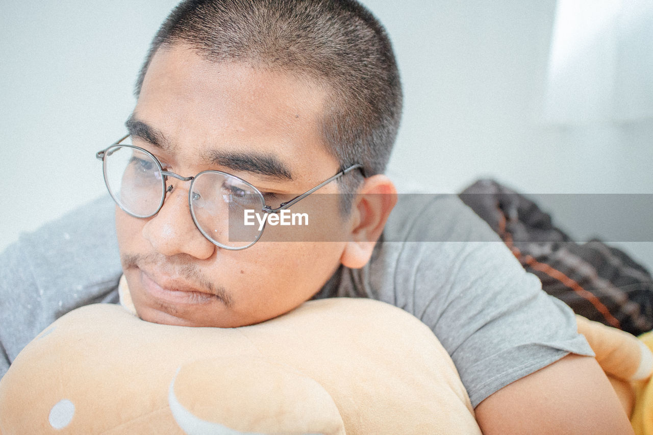 Close-up portrait of a man wearing eyeglasses at home