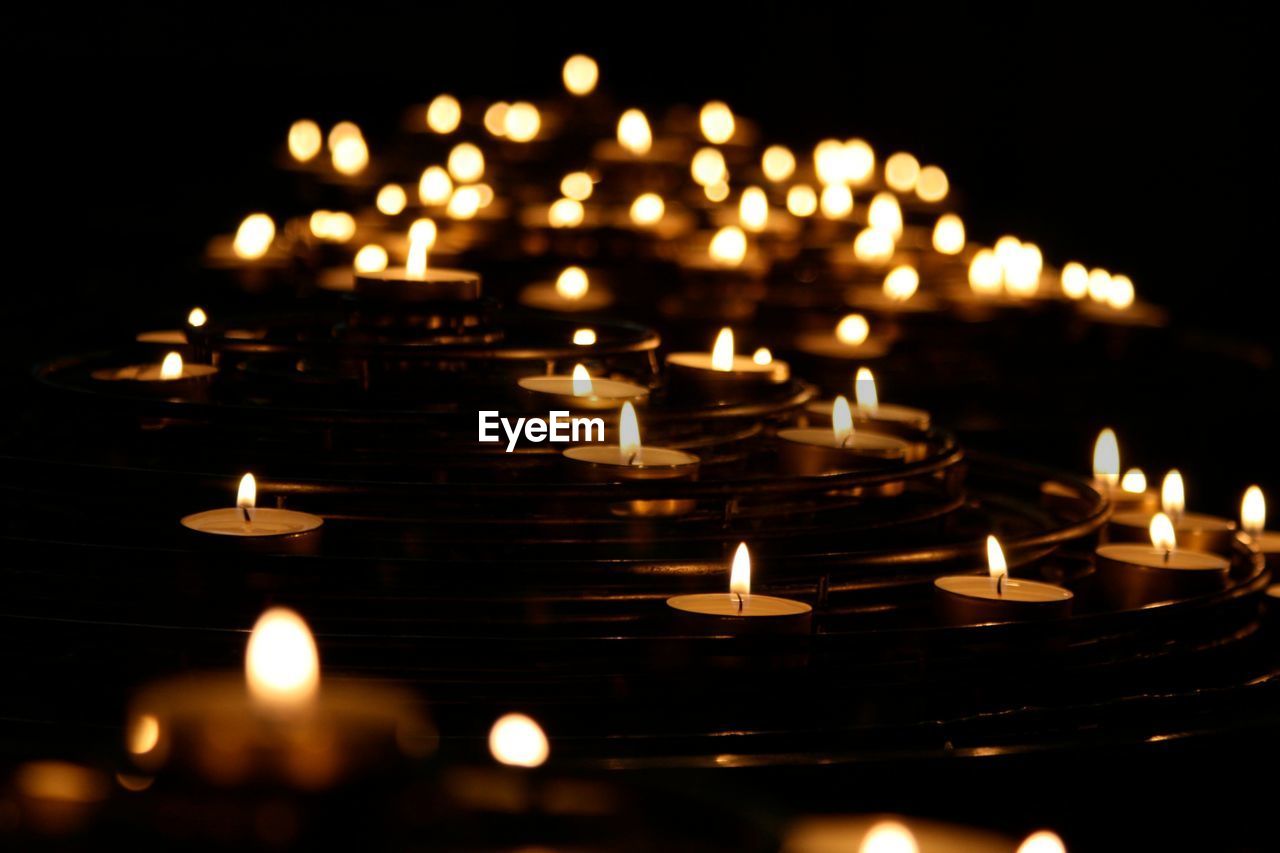 Close-up of lit candles in row