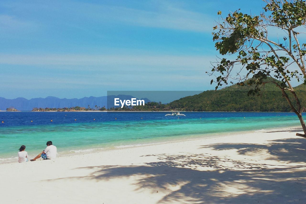 Man and woman sitting on beach