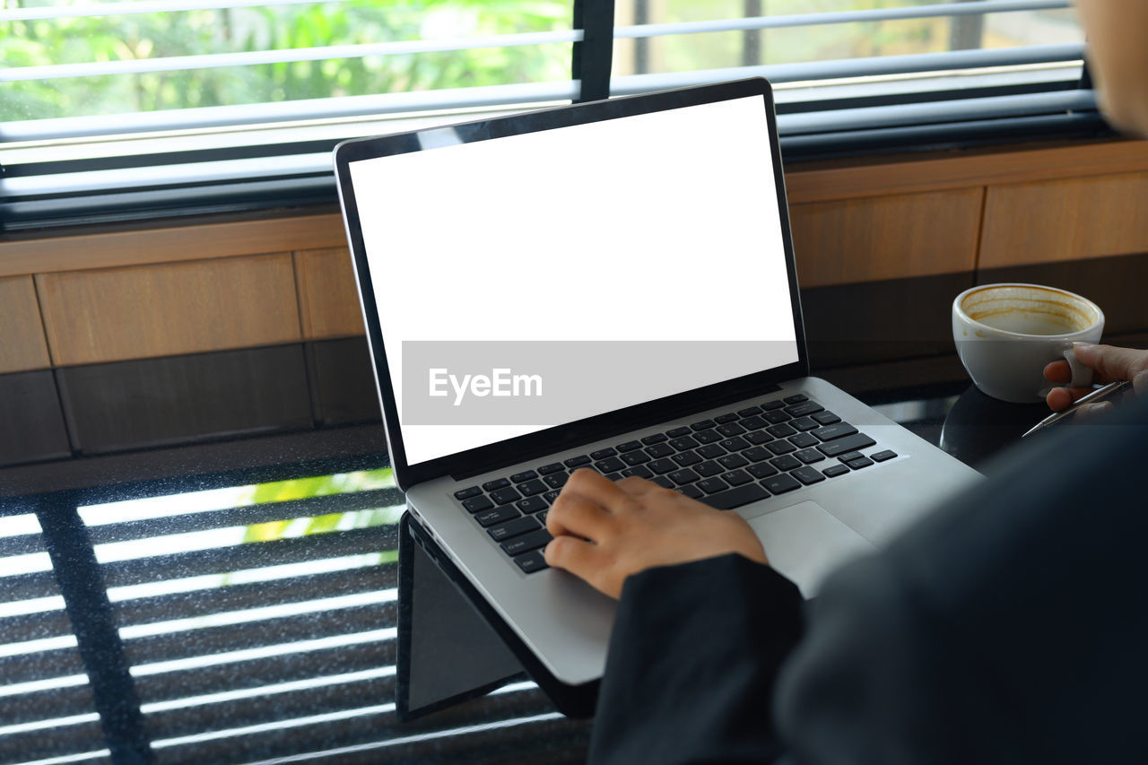 midsection of man using laptop at office