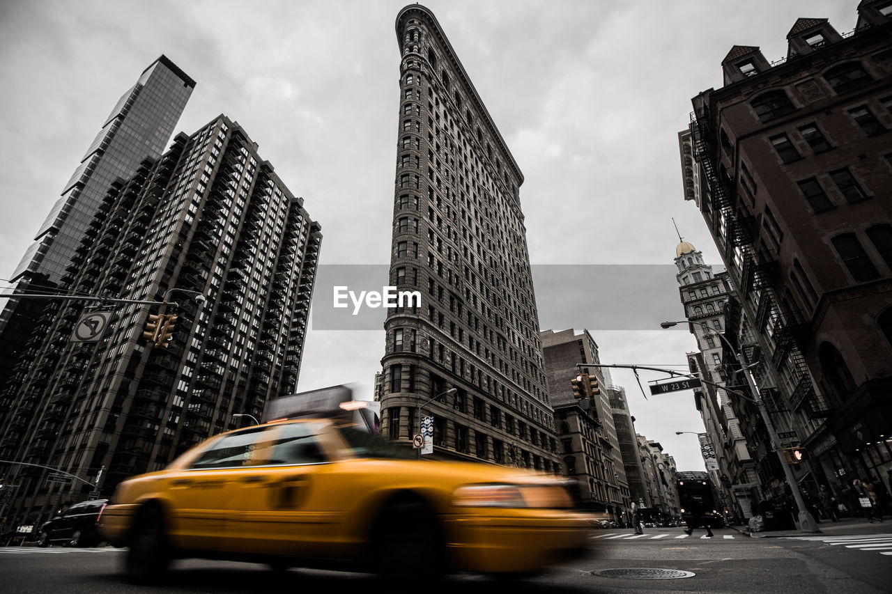 Low angle view of flatiron building against cloudy sky