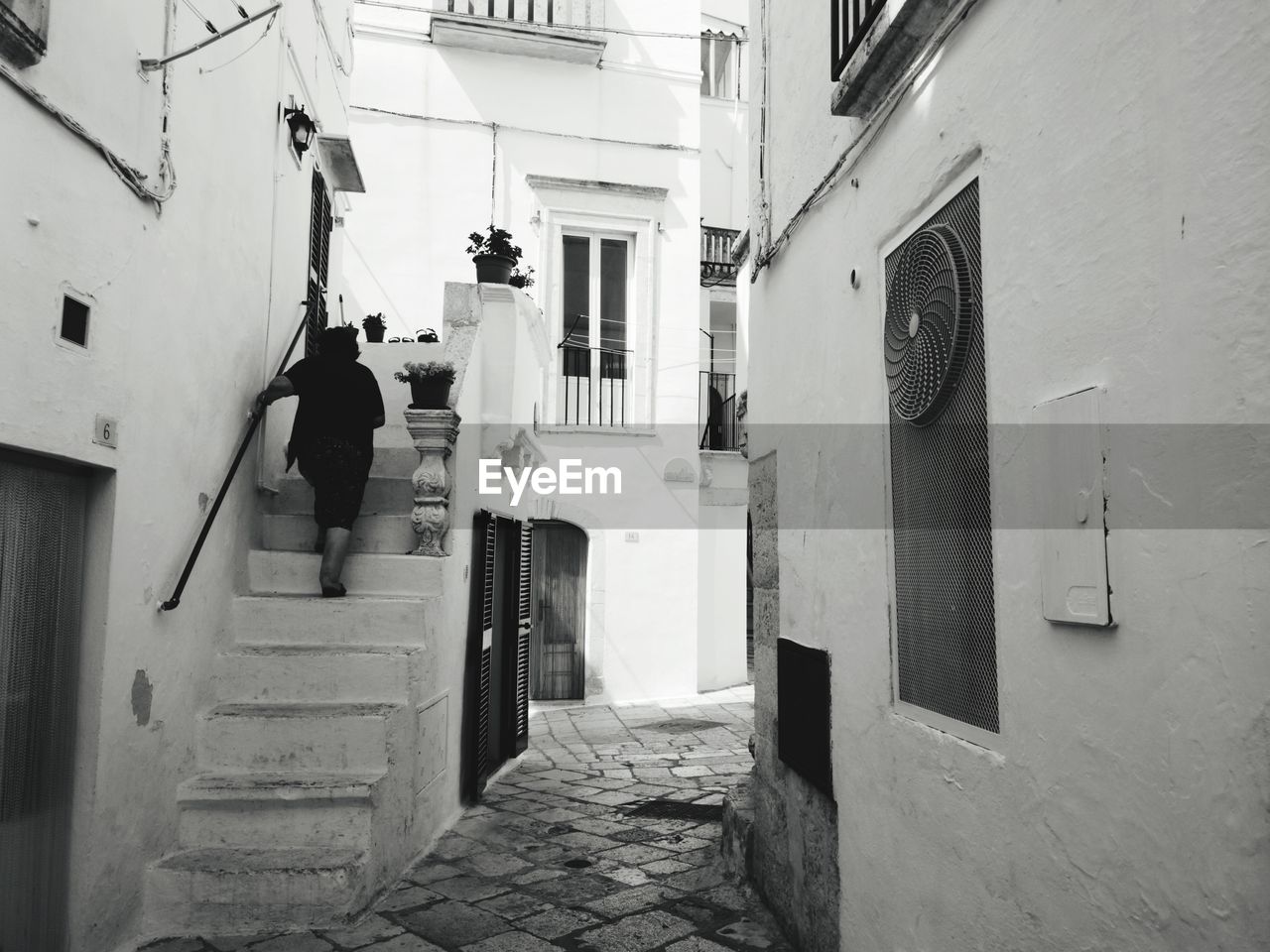 REAR VIEW OF PEOPLE WALKING ON RESIDENTIAL BUILDING