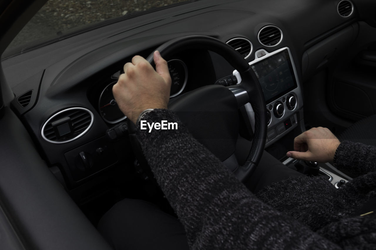 Midsection of man sitting in car