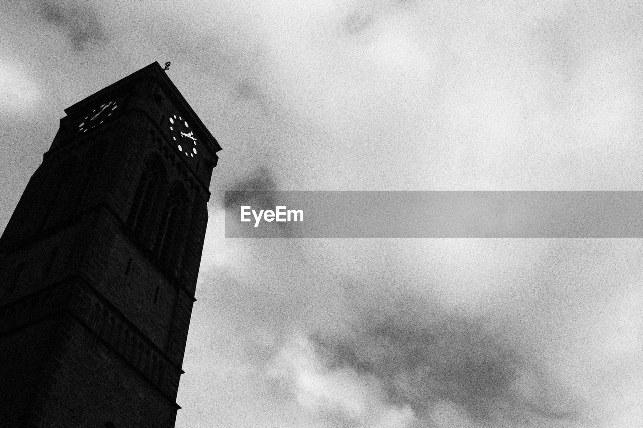 Low angle view of clock tower against cloudy sky