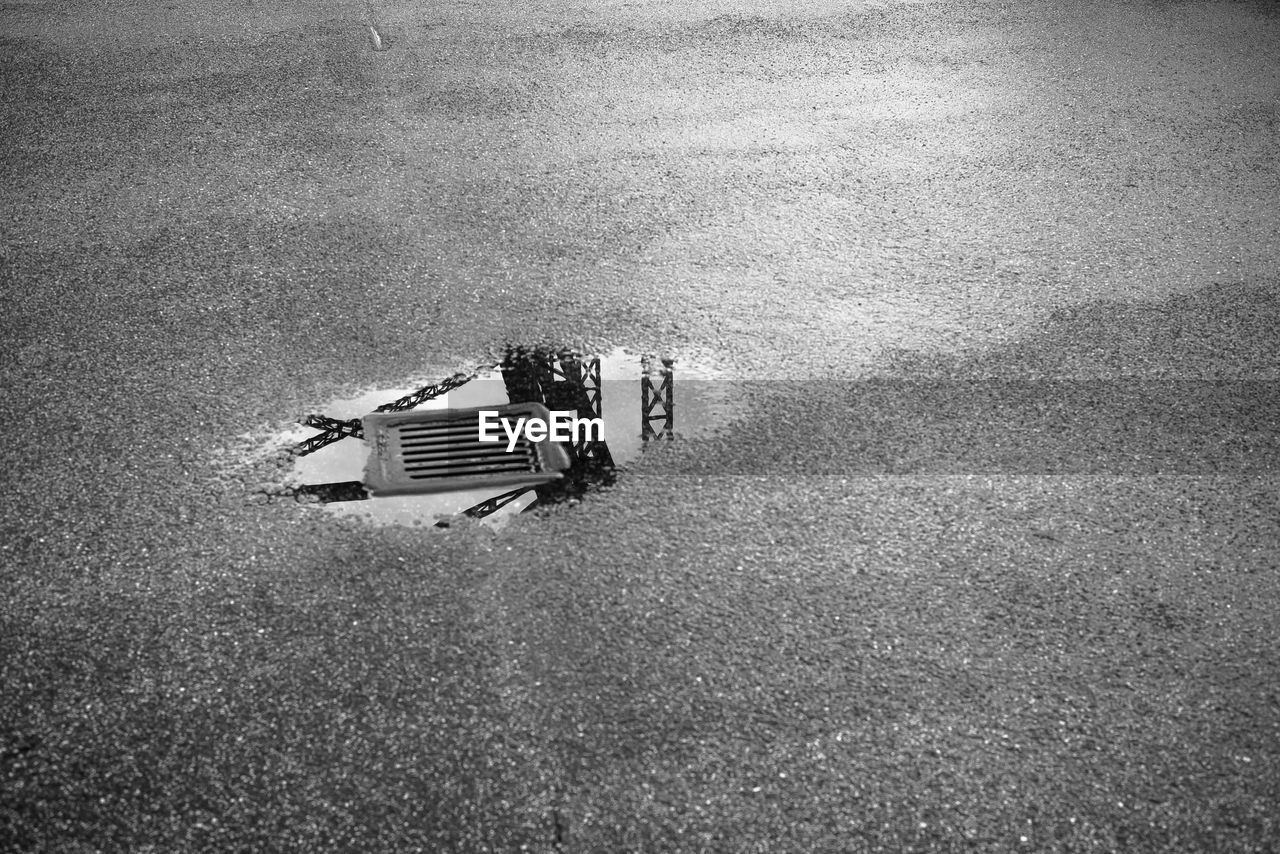 High angle view of bridge railing reflecting on puddle