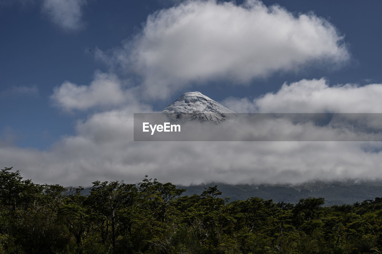 Landscape of the top of osorno volcano, appearing between clouds.