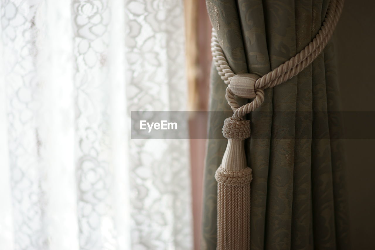 Curtain with tassel hanging at home