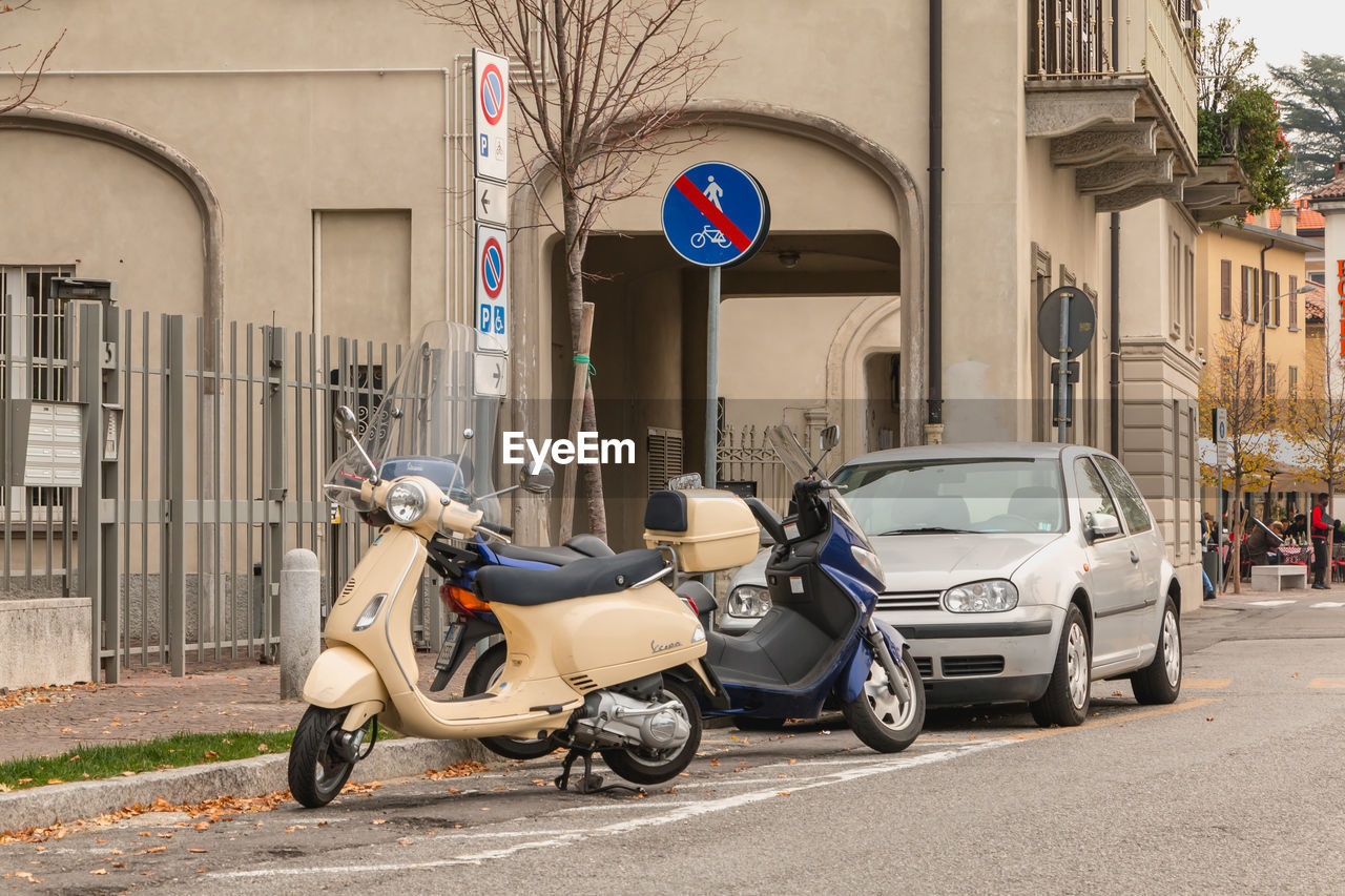 MOTORCYCLE PARKED ON STREET AGAINST BUILDING