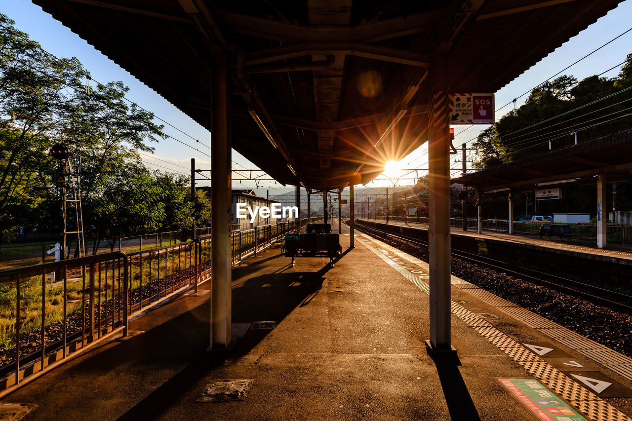 Empty railroad station platform during sunset
