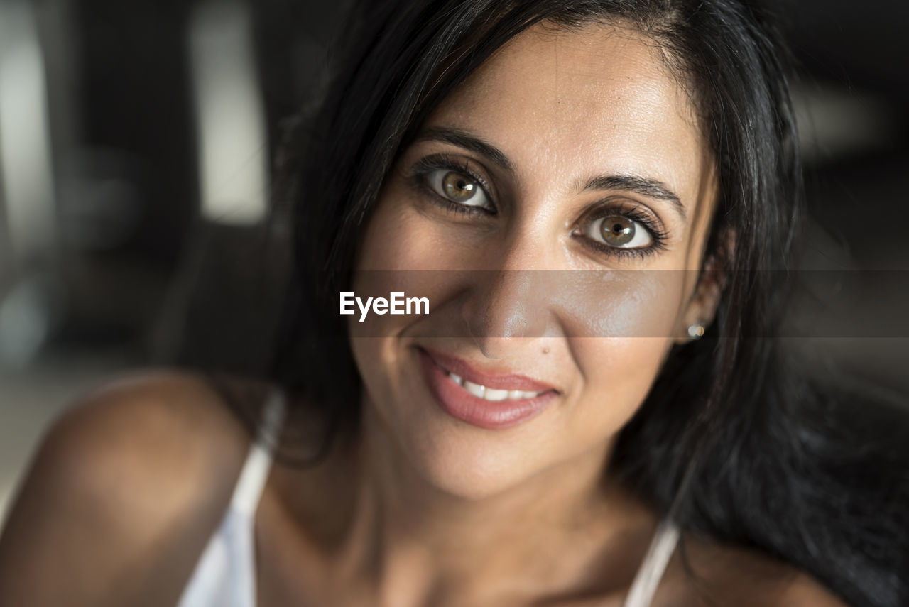 Close-up portrait of smiling woman at home