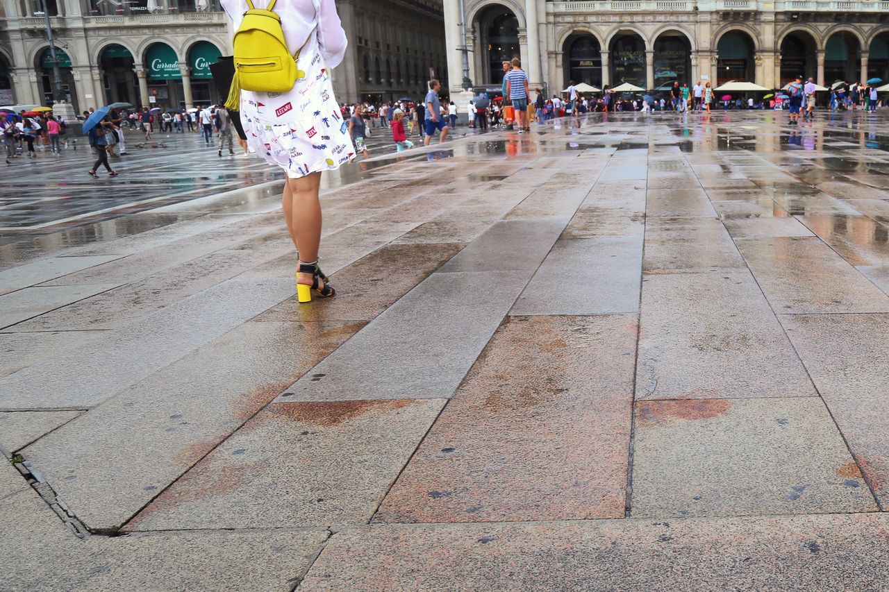 Rear view of woman walking on wet street at piazza del duomo