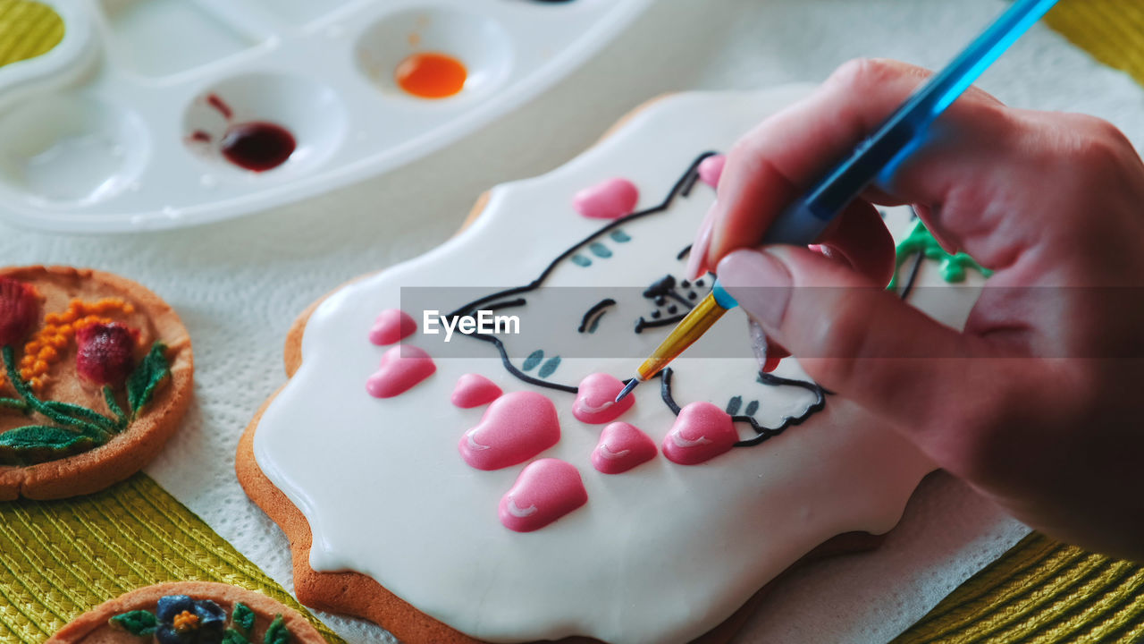 cropped hand of person painting on table