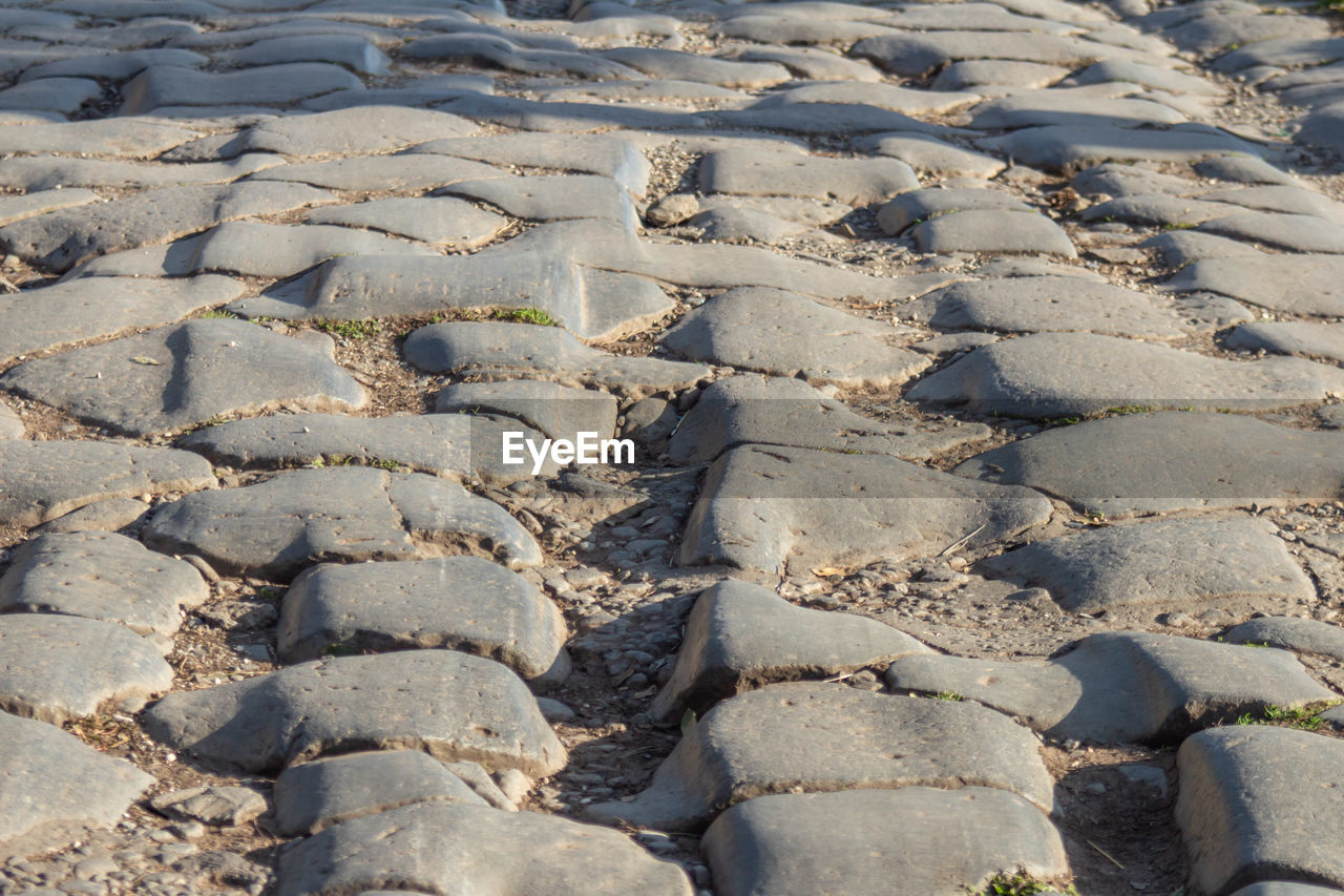 FULL FRAME SHOT OF PEBBLES ON SAND