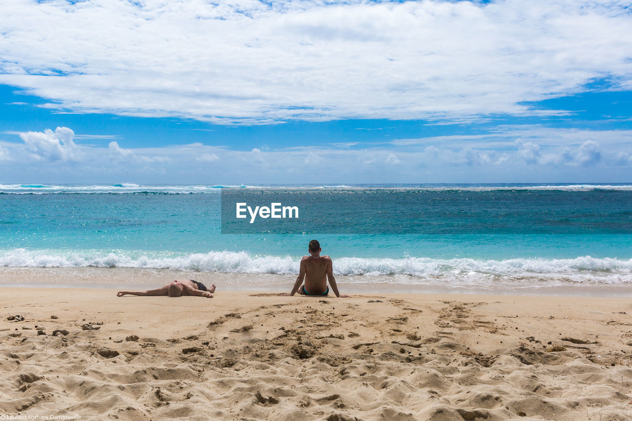 Scenic view of people lying on beach