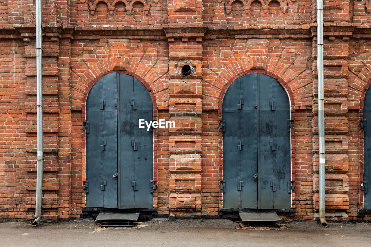 Close-up of a metal black door in old house a mansion made of old brick