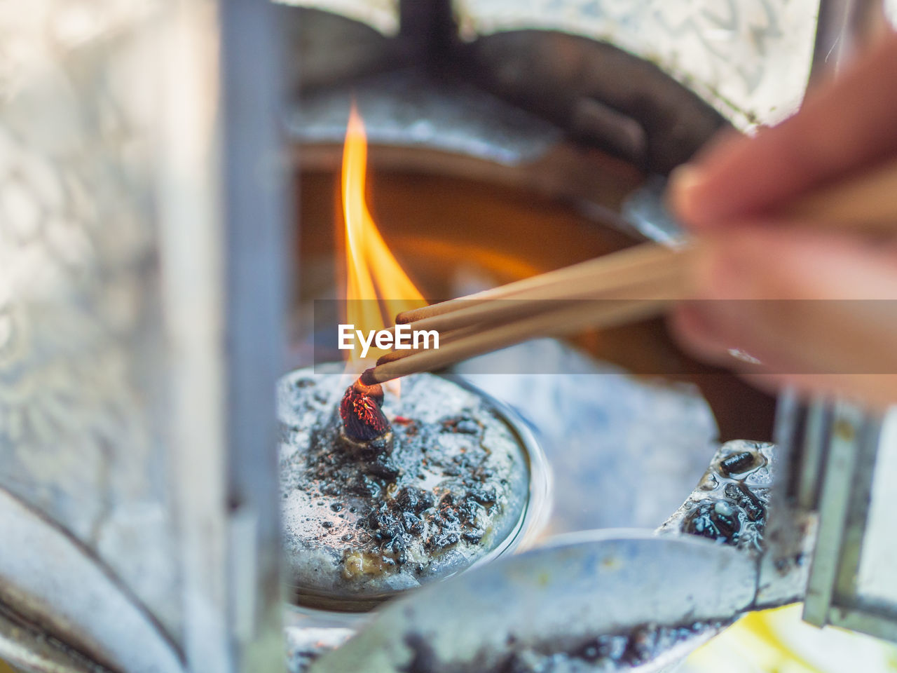 Cropped hand of person burning incense