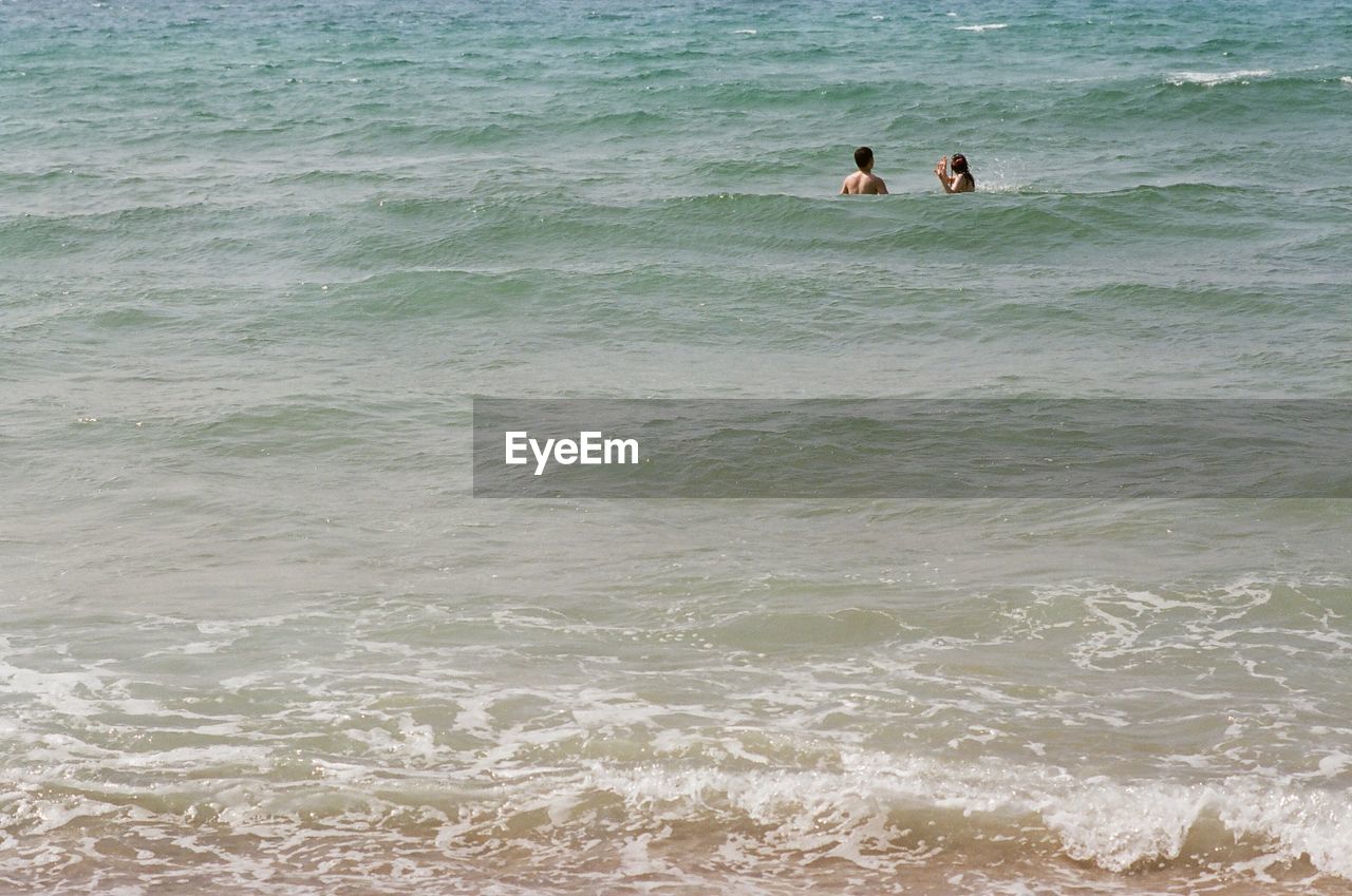 Man and woman standing in sea