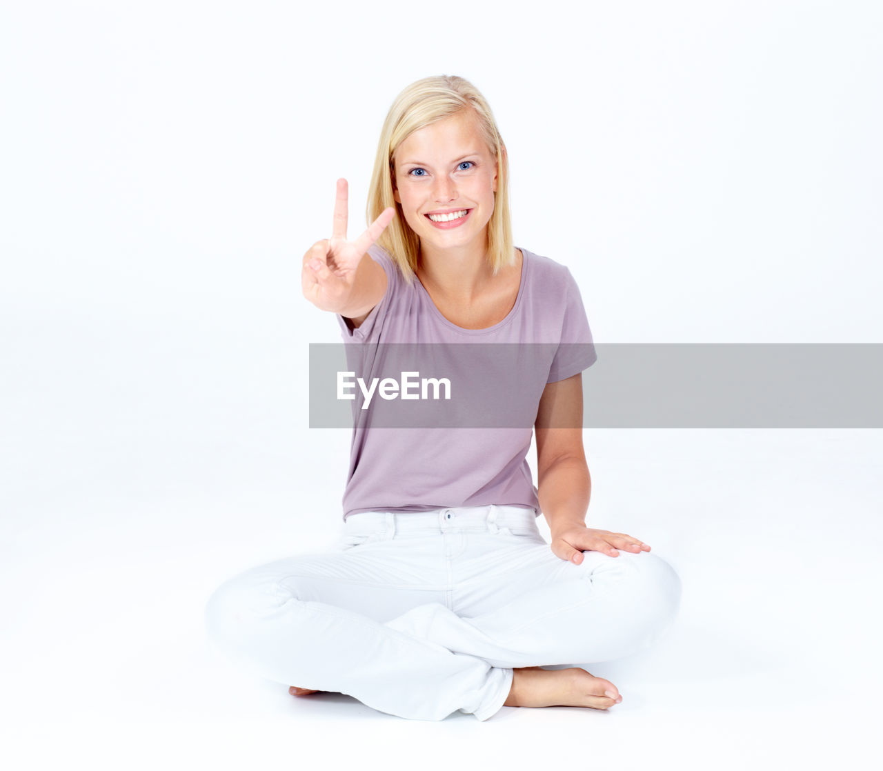 women, sitting, one person, blond hair, smiling, adult, white background, portrait, happiness, looking at camera, studio shot, relaxation, female, cut out, lifestyles, indoors, emotion, full length, physical fitness, wellbeing, young adult, yoga, front view, sports, exercising, cross-legged, positive emotion, cheerful, arm, teeth, person, smile, casual clothing, white, posture, copy space, finger, clothing, vitality, hand, cute