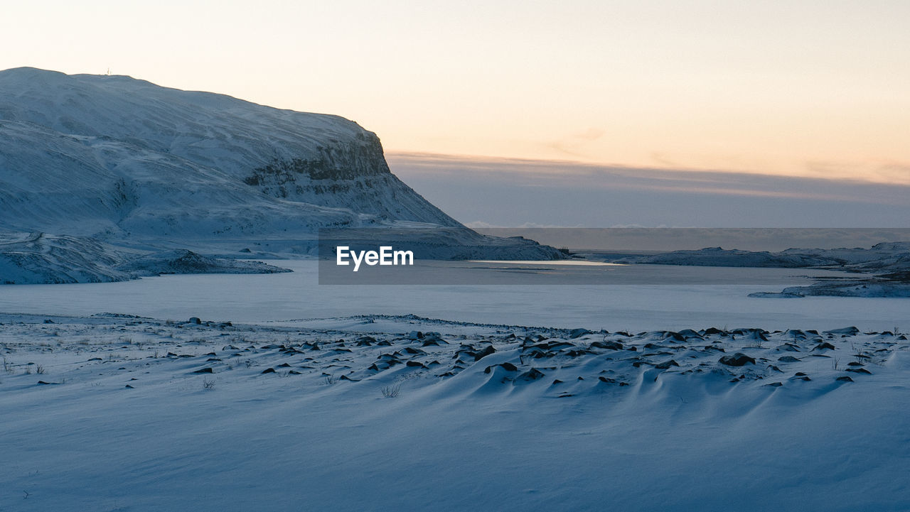 Scenic view of snowcapped mountains against sky during sunset