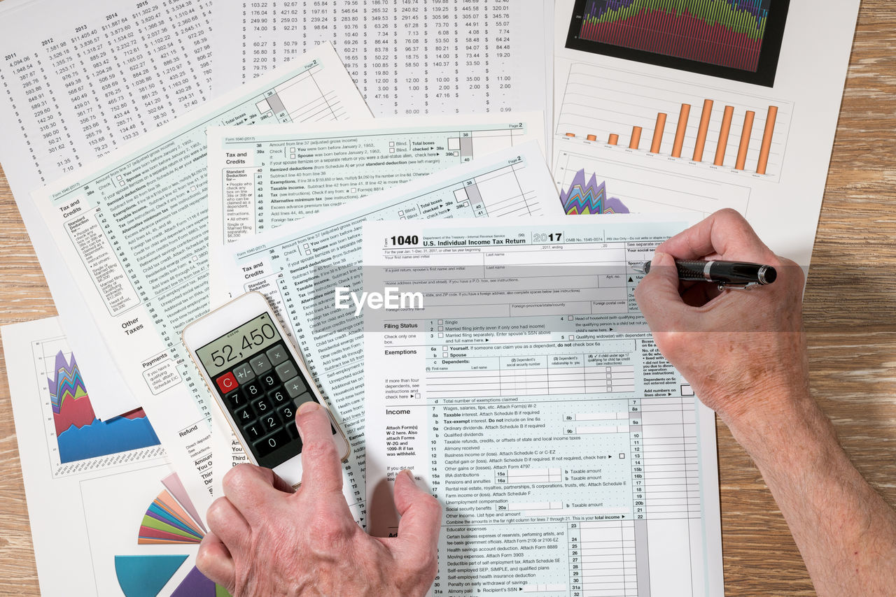 Cropped hands of man doing paperwork on table