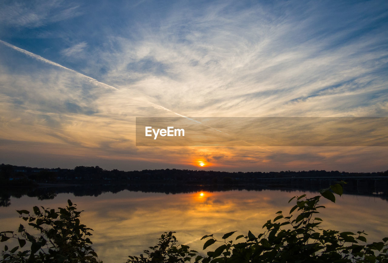 Idyllic view of calm lake against sky during sunset