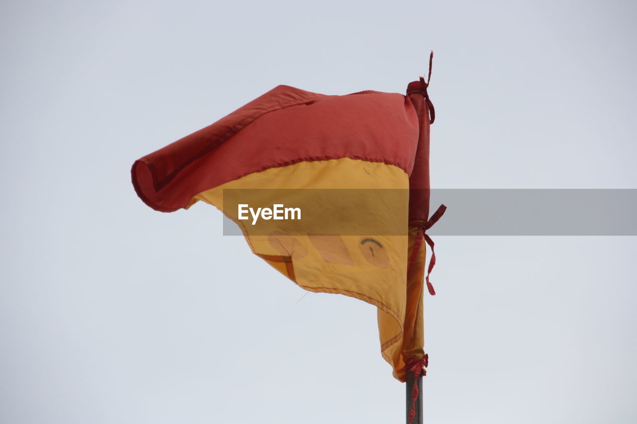 LOW ANGLE VIEW OF RED FLAG AGAINST SKY