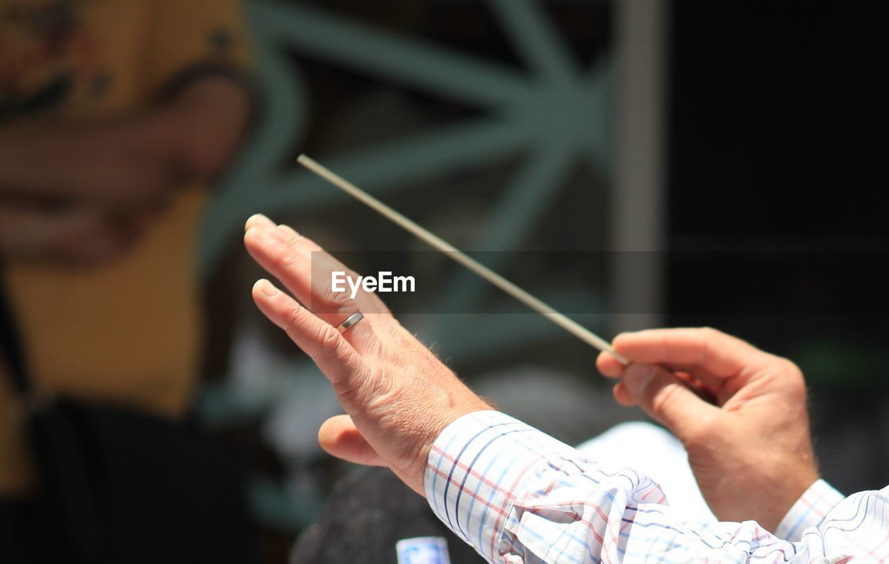 Cropped image of musical conductor holding stick